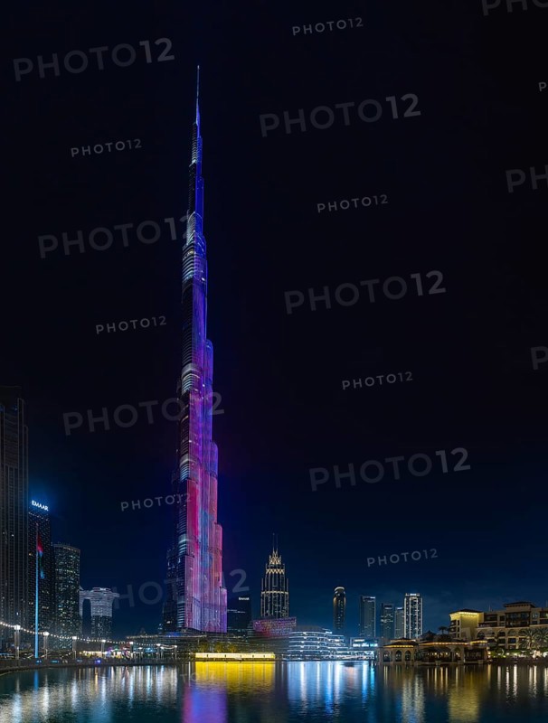 A picture of the iconic Burj Khalifa with its light show, and the surrounding Downtown Dubai buildings and Burj Khalifa Lake, at night