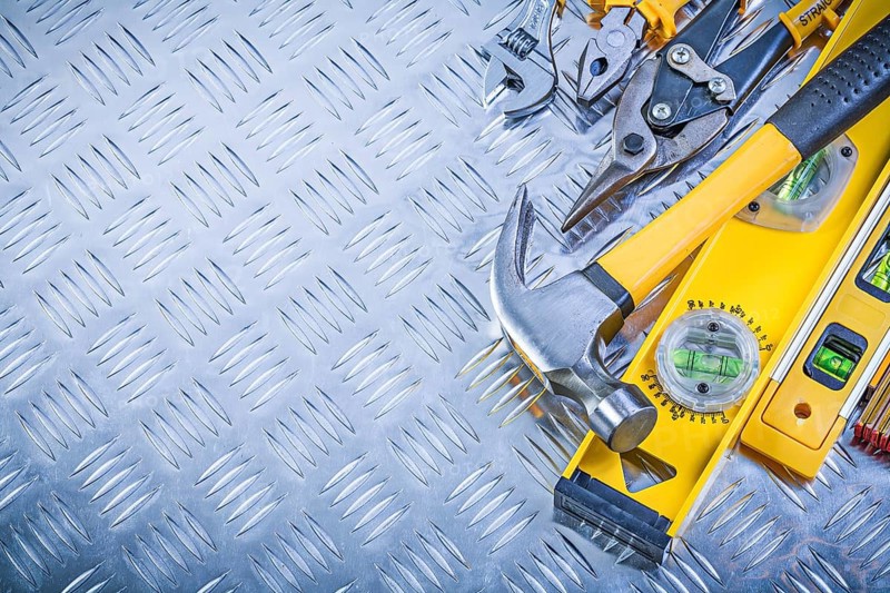 Set of construction tools on grooved metal plate maintenance concept