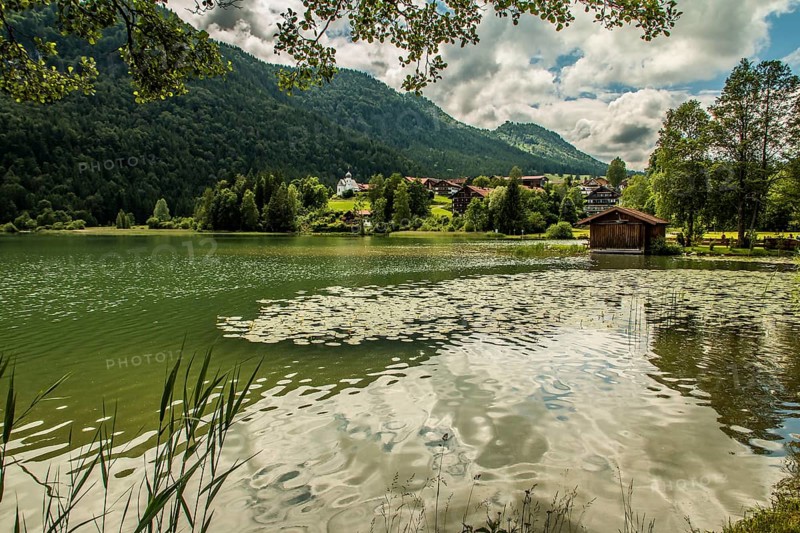 View over the Weissensee lake near Füssen in the Ostallgäu district to Oberkirch with the church of St Nicholas