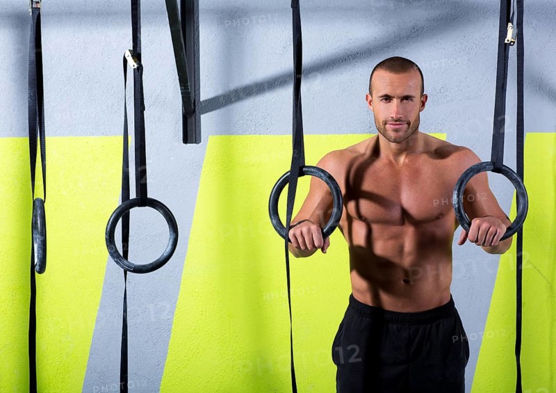 Crossfit dip ring man relaxed after workout at gym dipping exercise