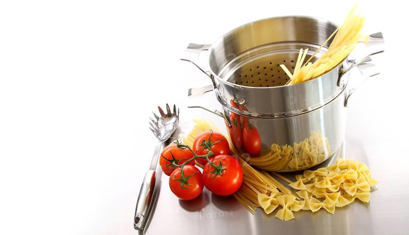 Stainless steel pot with uncooked pasta and tomatoes
