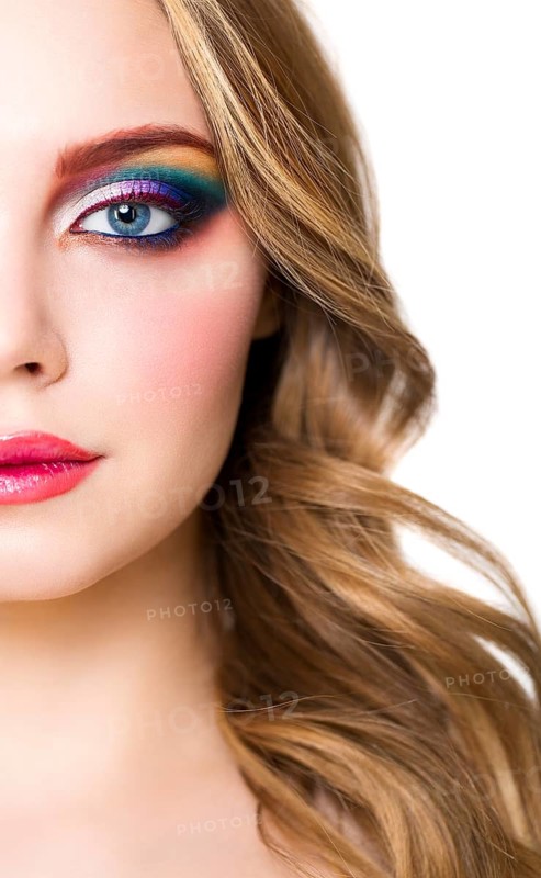 Close up portrait of a beautiful young blond model with bright make up. Close up of abstract multicolor make up. Makeup Pigment powder explosion