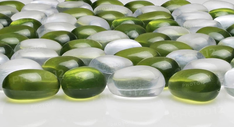 Artificial round stones of green and white color. imitation pebbles