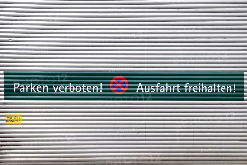 Rolltor mit der Aufschrift "Parken verboten und Ausfahrt freihalten" auf Deutsch