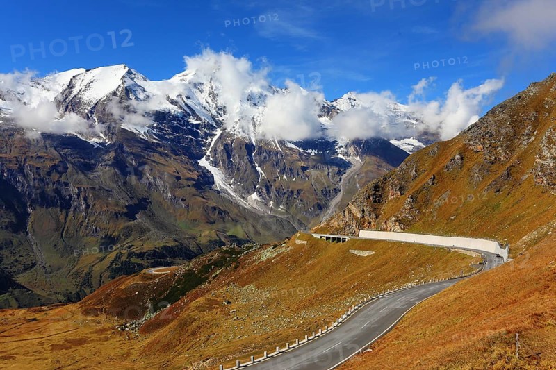 Famous picturesque views of the road in Austrian Alps - Grossglocknershtrasse. Ideal highway winds high in the mountains. The highest mountain peaks covered with fresh snow