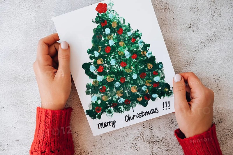 DIY Making greeting card Handmade crafts on holiday for children. Paint with fingers Merry Christmas tree. Top view. Step by step. Do it yourself. Happy New Year xmas tree decoration