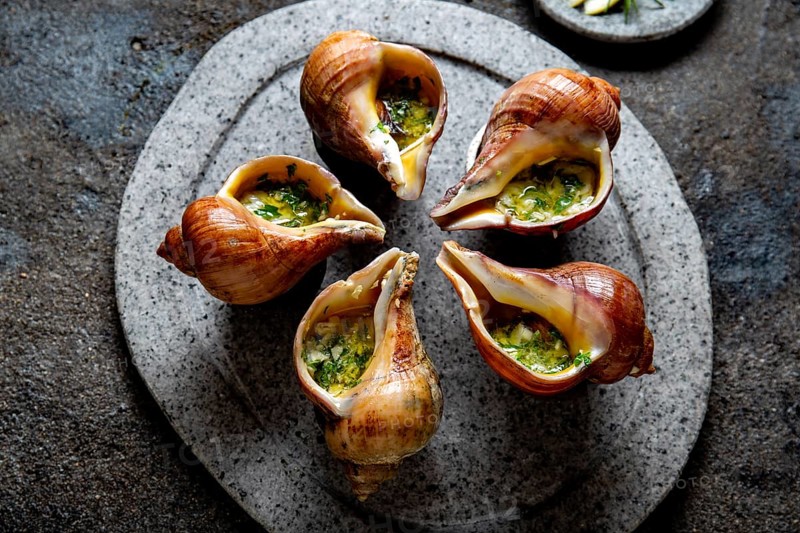 Food, Food, Chilean giant snails with butter, garlic and herbs on gray stone plate. escargot from pacific ocean