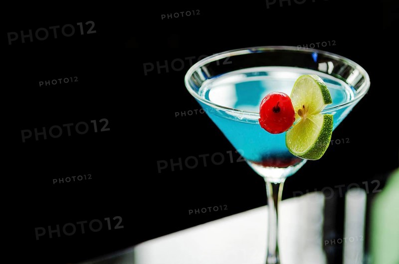 Blue curacao cocktail with cherry and lime