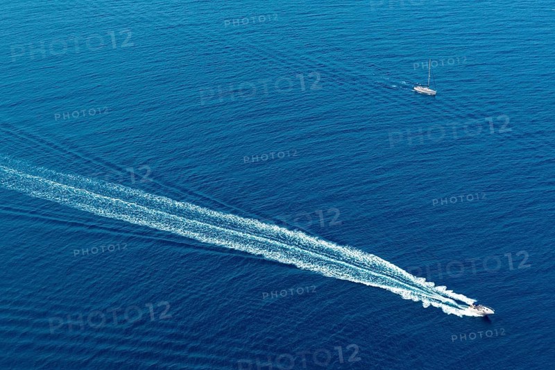 Boat surf foam aerial from prop wash in blue Majorca mediterranean sea