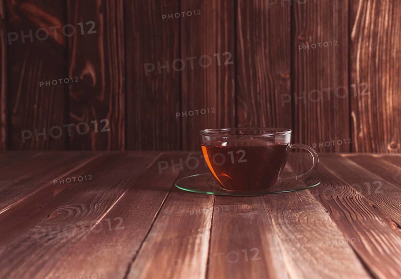 Glass cup of tea on a wooden table