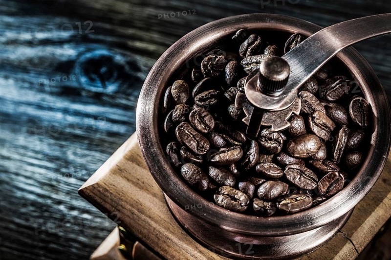 Coffee grinder beans on wooden board