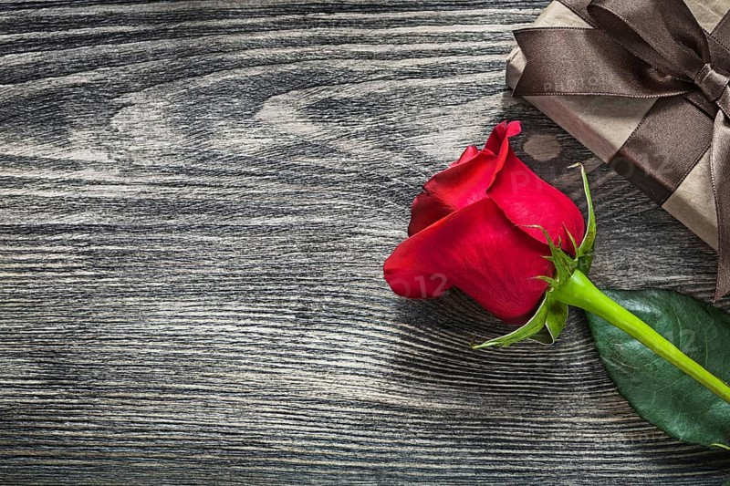 Red rose gift box on wooden board holidays concept