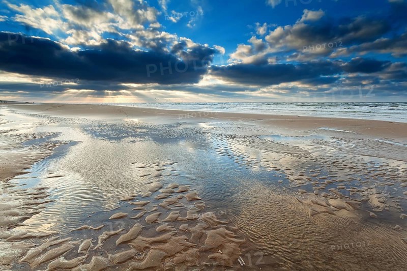 Sunshine over North sea beach at low tide, Netherlands