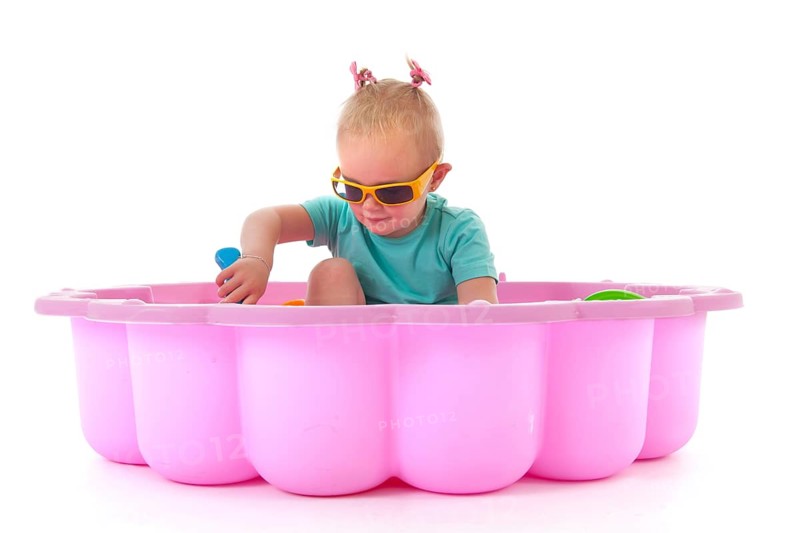 Toddler girl playing in swimming pool isolated over white background