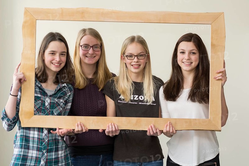 Group of girls smiling through a picture frame - portrait