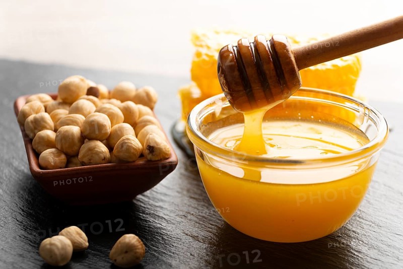 Slate tray with honey hazelnuts and honeycomb on kitchen table, food photography, food photography