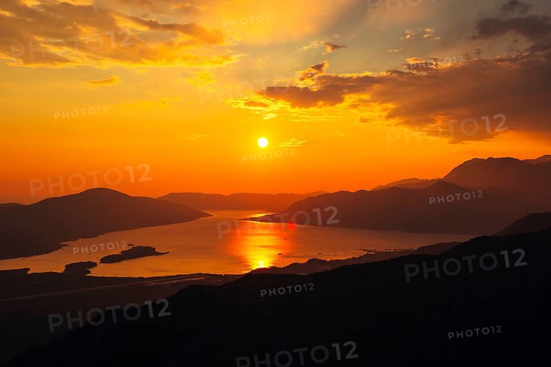 Sunset in Montenegro over the mountains and the sea. Orange sunsets