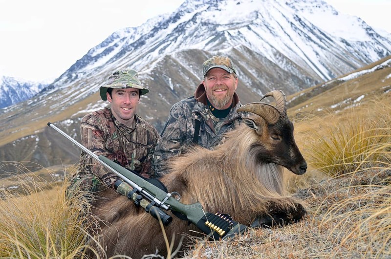 Hunters pose with their Himalayan tahr in the Southern Alps of New Zealand