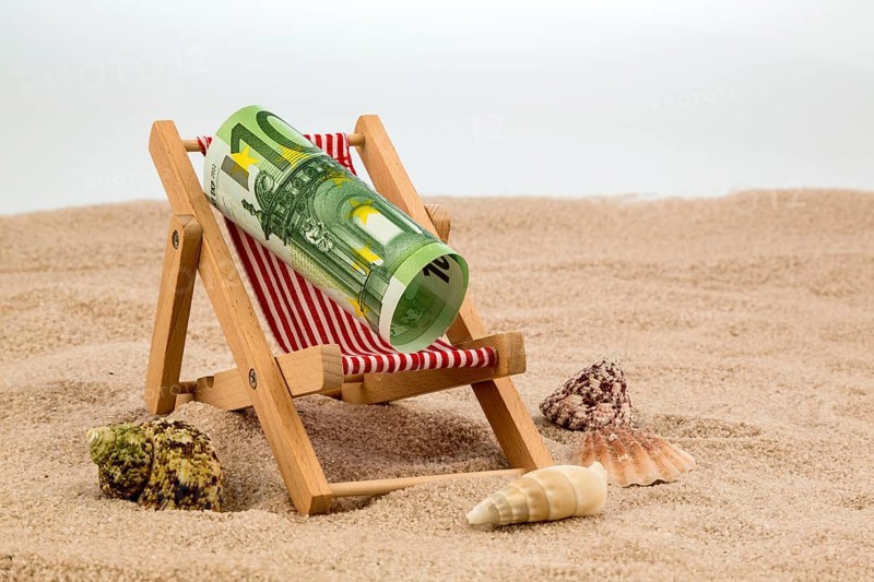 A deckchair with a euro banknote. Symbolic photo for saving on holiday and when travelling Austria