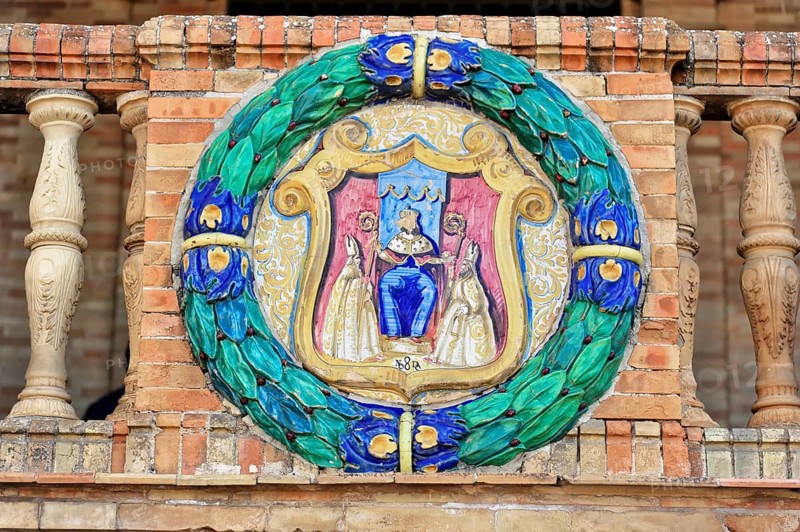 Plaza de España in Seville, Seville, Andalusia, Spain, Europe, A colourful relief of a coat of arms on a brick balustrade with a decorative wreath, Europe