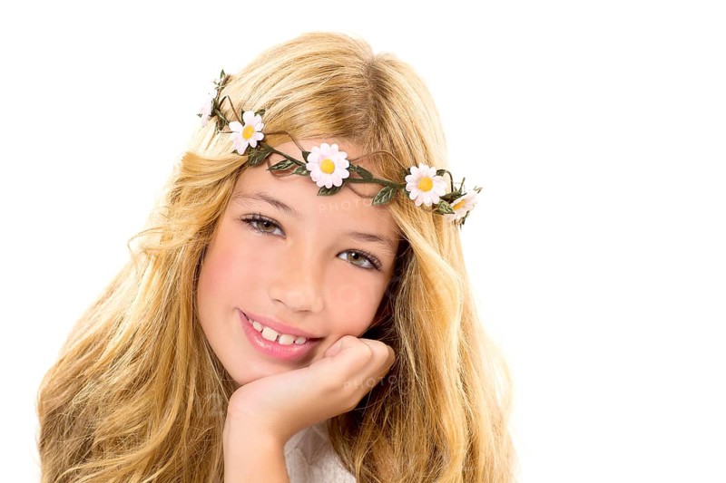 Children blond girl with spring daisy flowers crown smiling on white