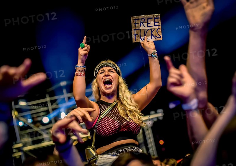 A female festival visitor with a sign at the Trailerpark concert with the inscription Free Fucks