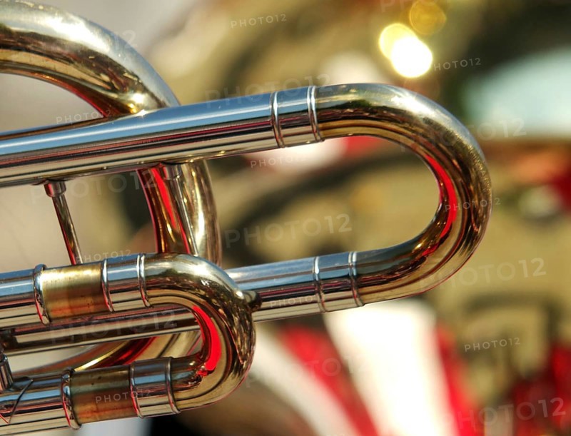 Abstract backgrounds of brass band instruments with details of a trombone in the foreground