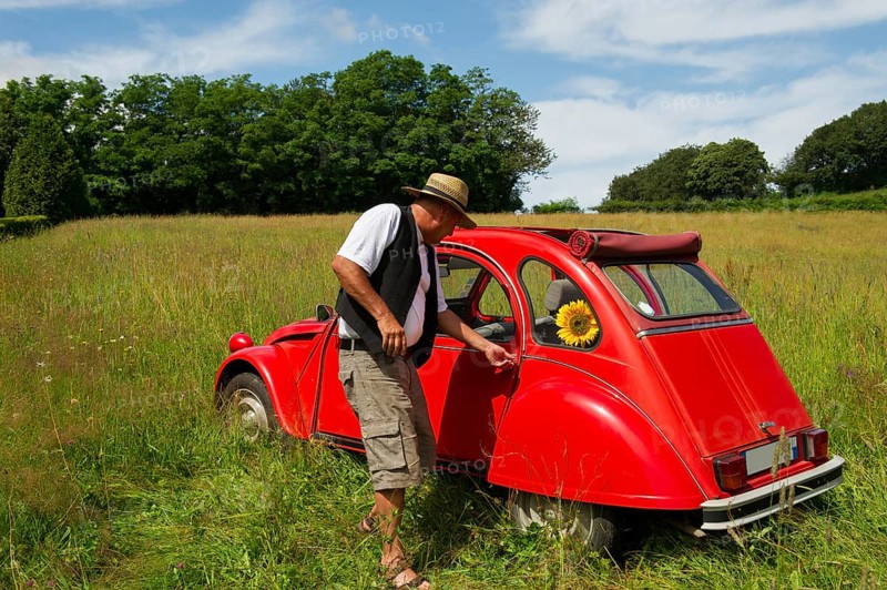 Typical French man is opening the door of his French car