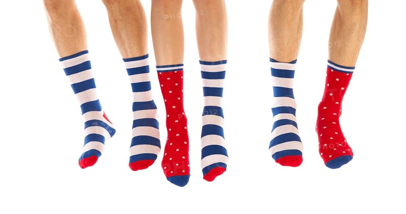 Feet in striped and dotted socks isolated over white background
