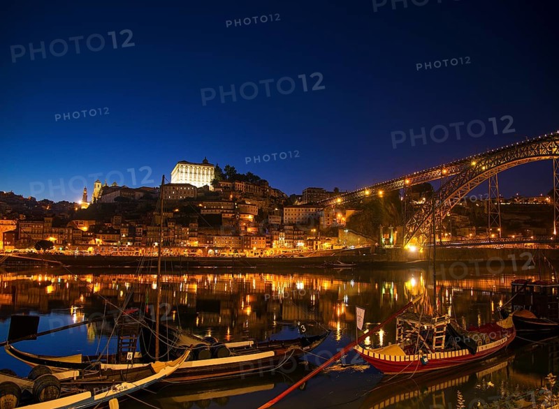 Old town river area of porto in portugal at night with rabelo boats
