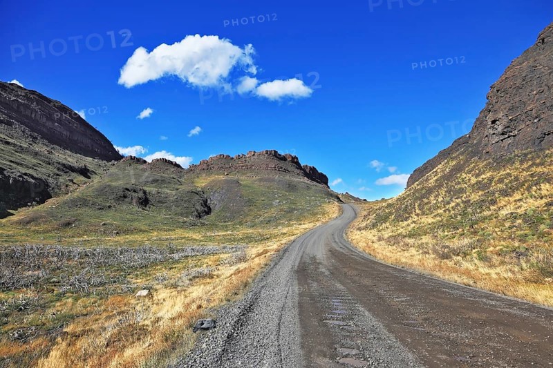 Beautifully curved gravel road between the hills. The National Park Torres del Paine. Chilean Patagonia