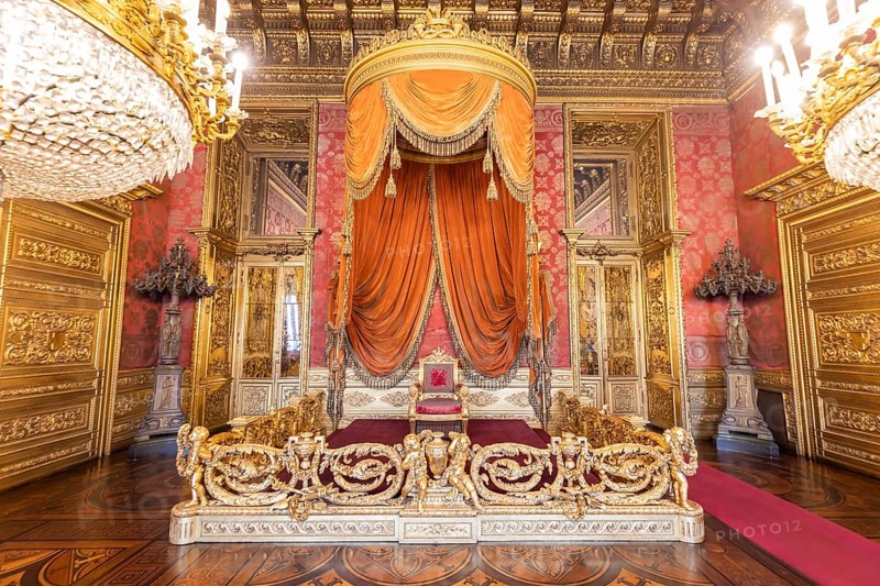 Turin, Italy, Circa August 2021: old throne room interior with chair in luxury palace. Red and gold antique Baroque style, Savoia Royal Palace, Europe