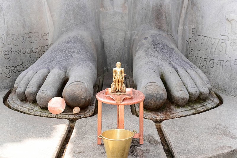 Gomateshwara statue, Jaina-Asket, Jain temple on Vindyagiri Hill, Shravanabelagola, Karnataka, South India, India, Close-up of the feet of a stone statue with a small metal figure in front of it, Mysore, Karnataka, South India, India, Asia