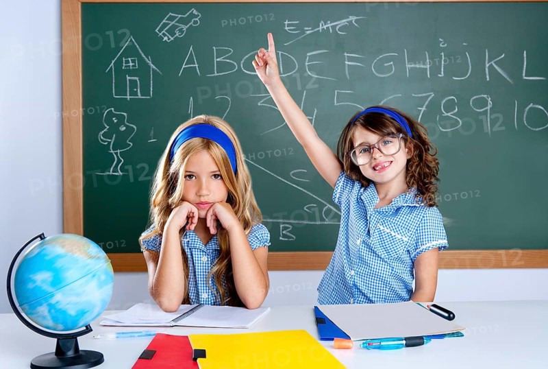 Smart nerd student in classroom raising hand with sad friend