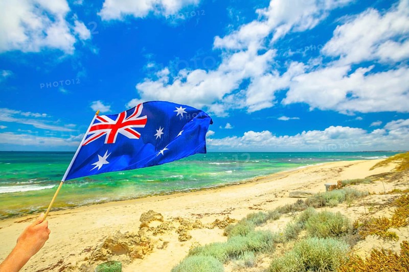 Australian flag waving on the foreground with coastal landscape of Mettams Pool, Trigg Beach, North Beach near Perth in Western Australia. Tourism in Australia, North Beach, Australia, Oceania