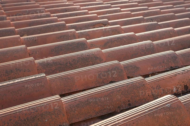 Close up of the red clay roof tiles. Background of old roof