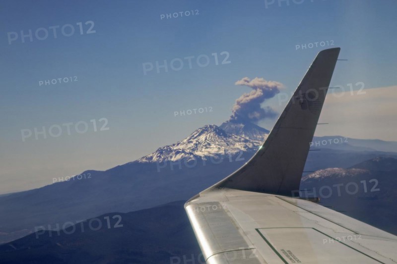 Mexico City, An AeroMexico jet flies past the erupting Popocatepetl volcano