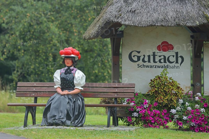 Doll in woman's traditional costume with Bollenhut on bench, Black Forest, Bollenhut, clothing, skirt, tradition, traditional, sitting, park bench, inscription, sculpture, floral decoration, Gutach-Black Forest railway, Ortenau, Southern Black Forest, Black Forest, Baden-Württemberg, Germany, Europe