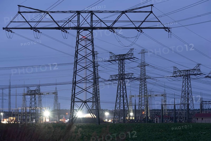 High-voltage pylons illuminated at dusk, industrial environment, quiet atmosphere, Wolmirstedt, Saxony-Anhalt, Germany, Europe