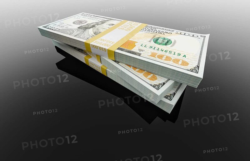 Stack of thirty thousand dollars of one hundred dollar bills on black reflective surface.