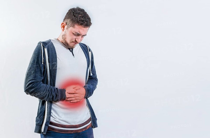 Unhappy man with digestive problems isolated. Person with digestive and stomach problems isolated