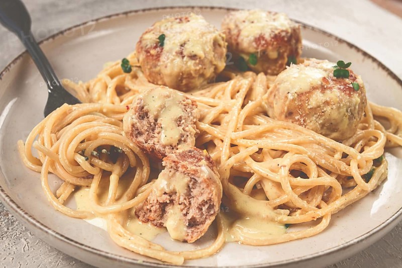Spaghetti with chicken meatballs, with cream sauce, and parmesan cheese, and decorated with microgreens, homemade, no people