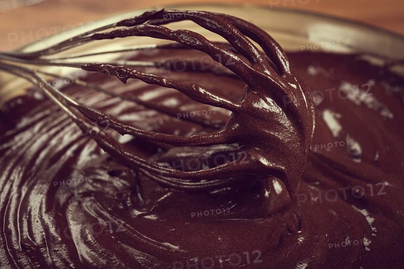 A bowl of chocolate dough, a whisk for whipping, baking, structure and consistency, homemade, top view, no people