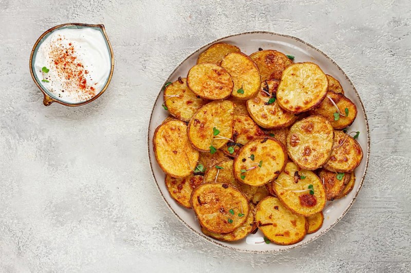 Crispy potato slices, with parmesan cheese and spices, fried in the oven, homemade, no people