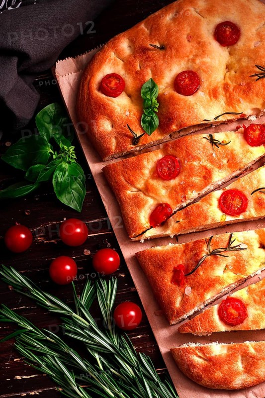Focaccia, Italian flatbread, with cherry and rosemary, close-up, garlic bread, top view, vertical, no people, homemade