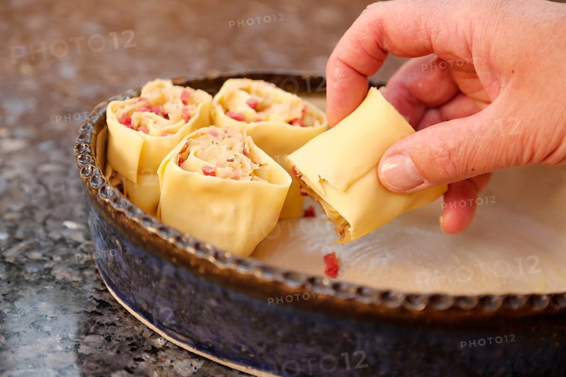 Swabian cuisine, preparation of Krautkrapfen, Swabian Mehlsäck, stuffed pasta pancakes with sauerkraut and smoked meat in a casserole dish, hearty, savoury, main course, raw pasta pancakes, grandmother's kitchen, regional, home cooking, typical Swabian, traditional cuisine reinterpreted, men's hands, food photography, studio, Germany, Europe