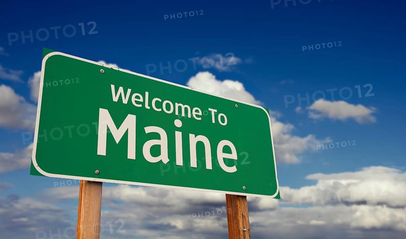 Welcome to maine green road sign over blue sky with some clouds