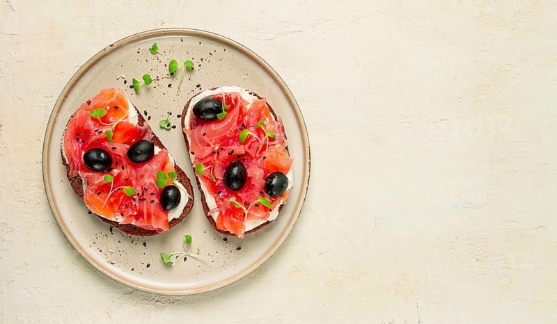 Sandwiches with red fish, cream cheese, olives and microgreens, breakfast