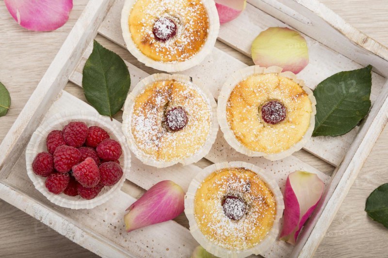 Cheesecake muffins with icing sugar and raspberries