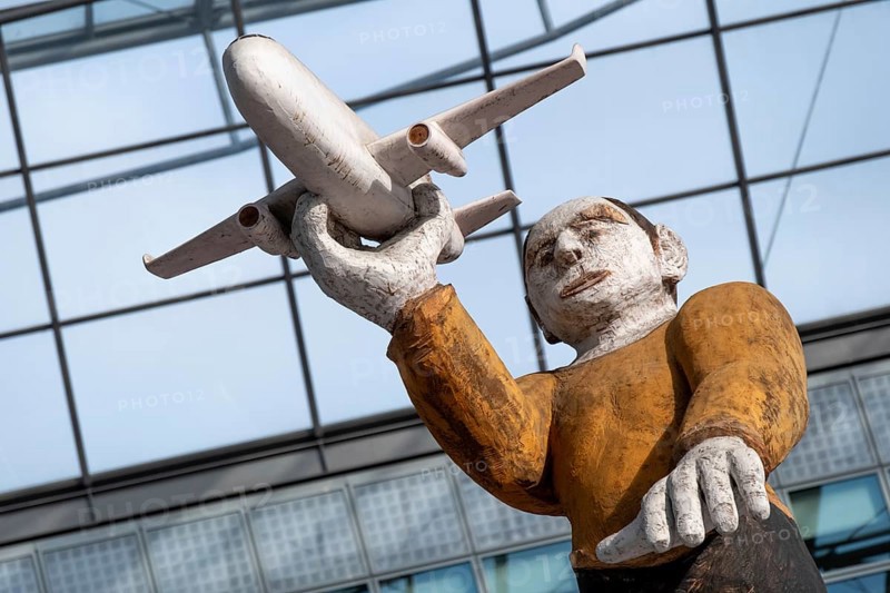 Sculpture, wooden figure with aeroplane at Munich Airport, Terminal 2, Munich, Bavaria, Germany, Europe